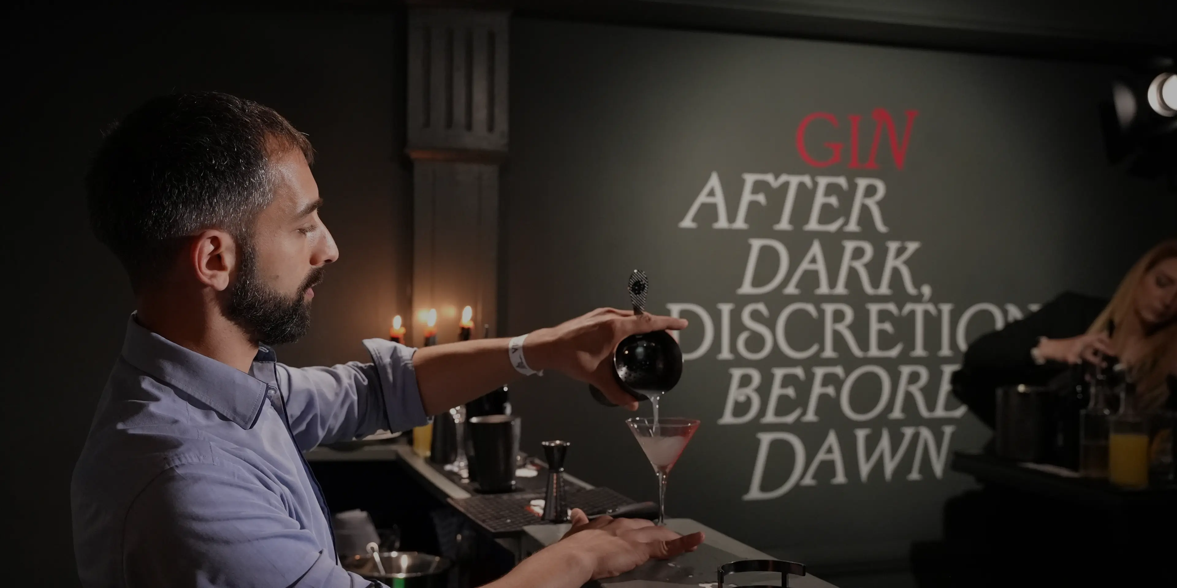 Mixologist pouring cocktail into a glass